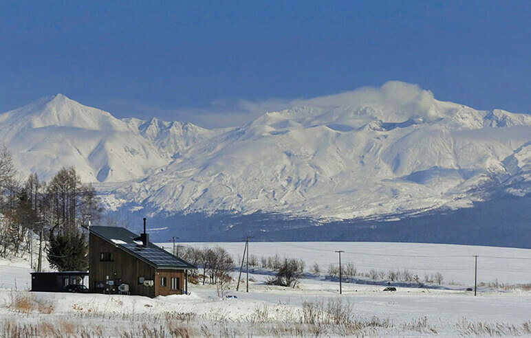 真冬の雪景色に自然と馴染むSさん宅。入居した昨年11月中旬の美瑛の気温は－5℃。「雪が積もっていましたが、家の中は暖かでした。－25℃以下まで冷え込んだ夜、薪ストーブを消して寝ても朝凍えることもなく、300㎜断熱の効果を実感しました