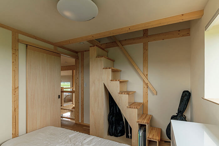 主寝室からロフトに上がる、収納機能も備えた階段たんす